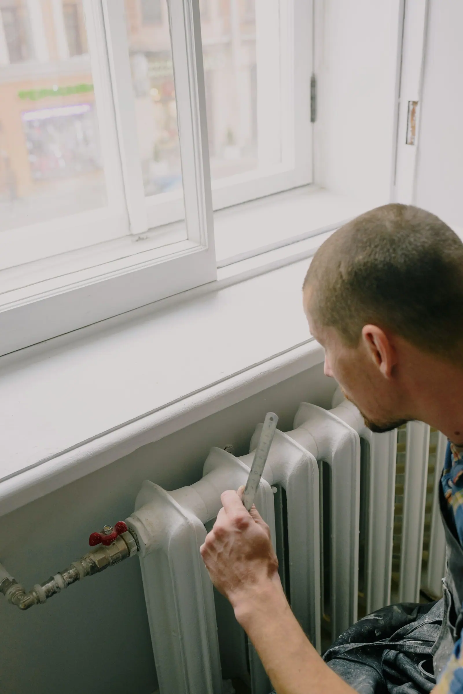 Professionnel relevant les dimensions d'un radiateur au mètre pour dimensionner l'installation