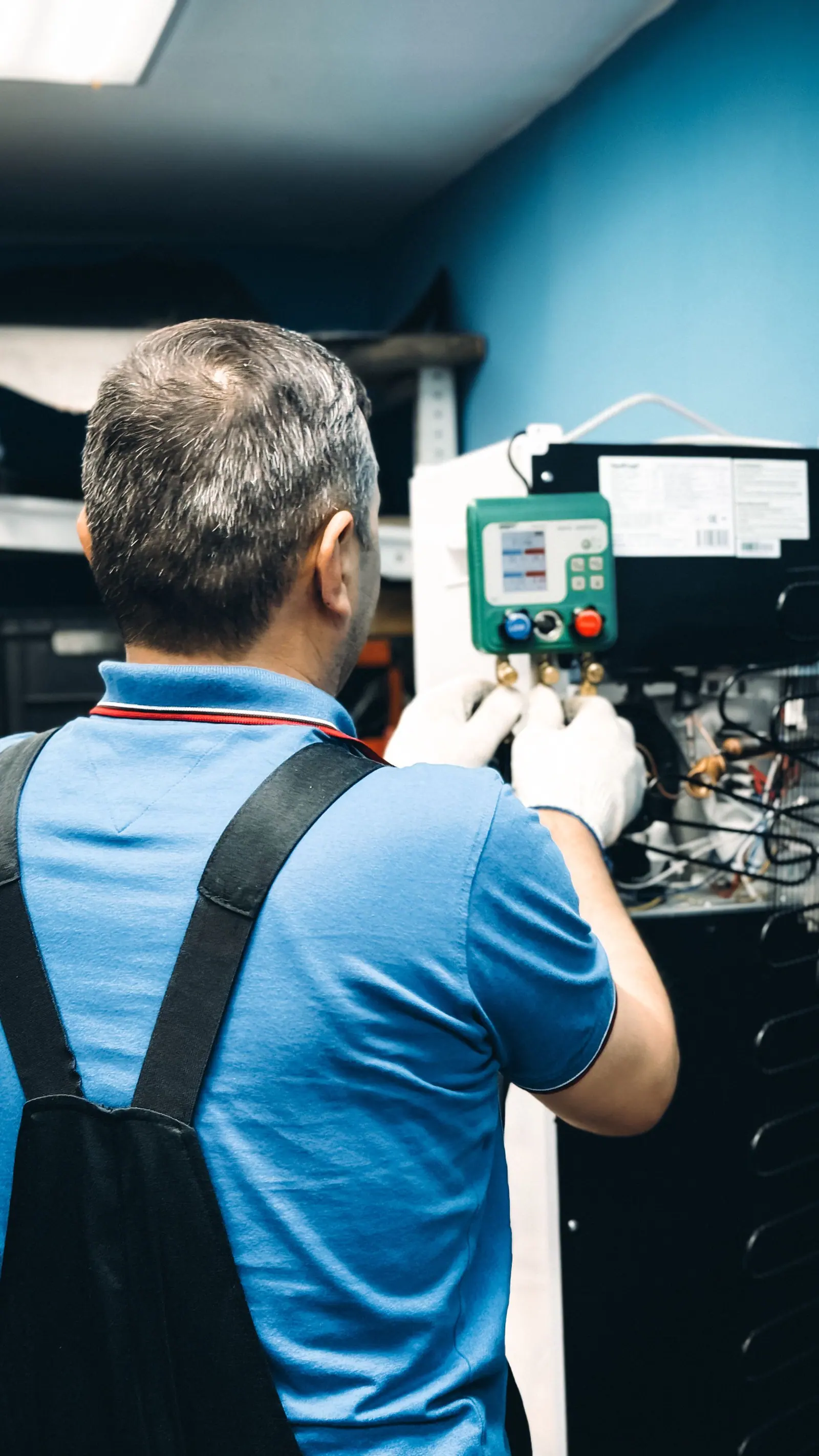 Technicien réalisant la maintenance d'une installation thermique en intérieur