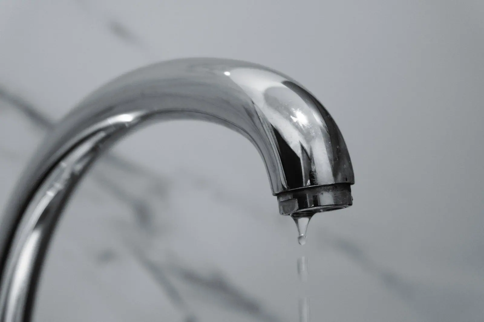 Goutte d'eau tombant d'un robinet, illustrant une fuite persistante sur un circuit