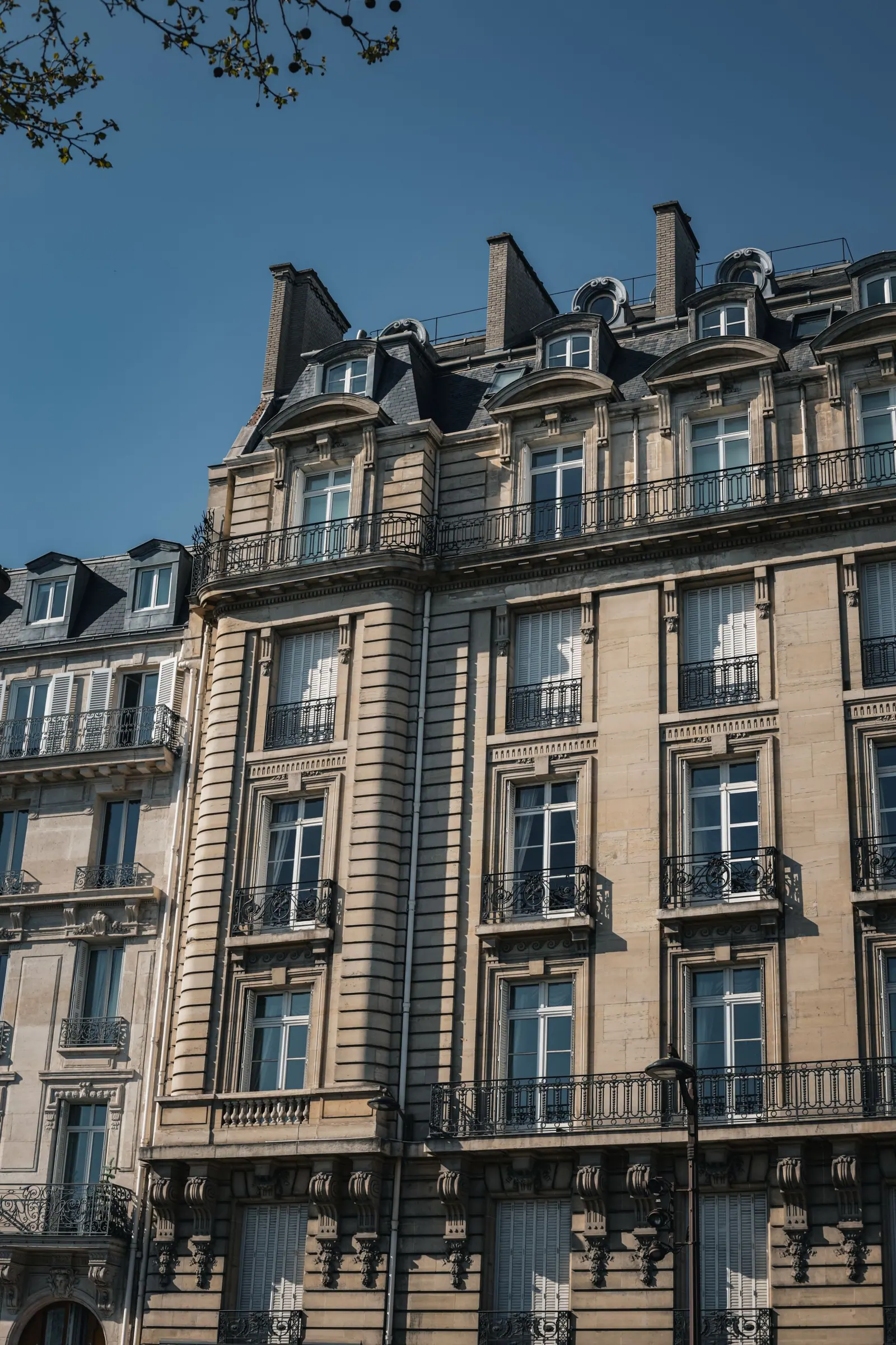 Façade d'un immeuble parisien du XIXᵉ siècle avec balcons en ferronnerie