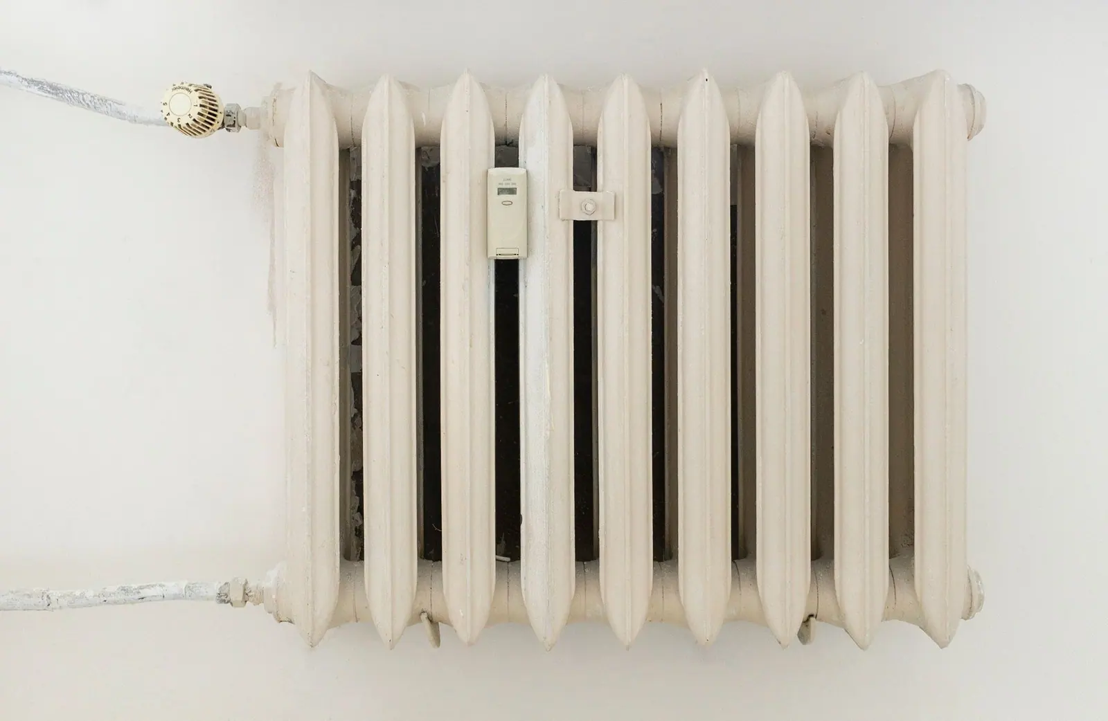 Radiateur acier à ailettes installé dans une pièce lumineuse récemment rénovée