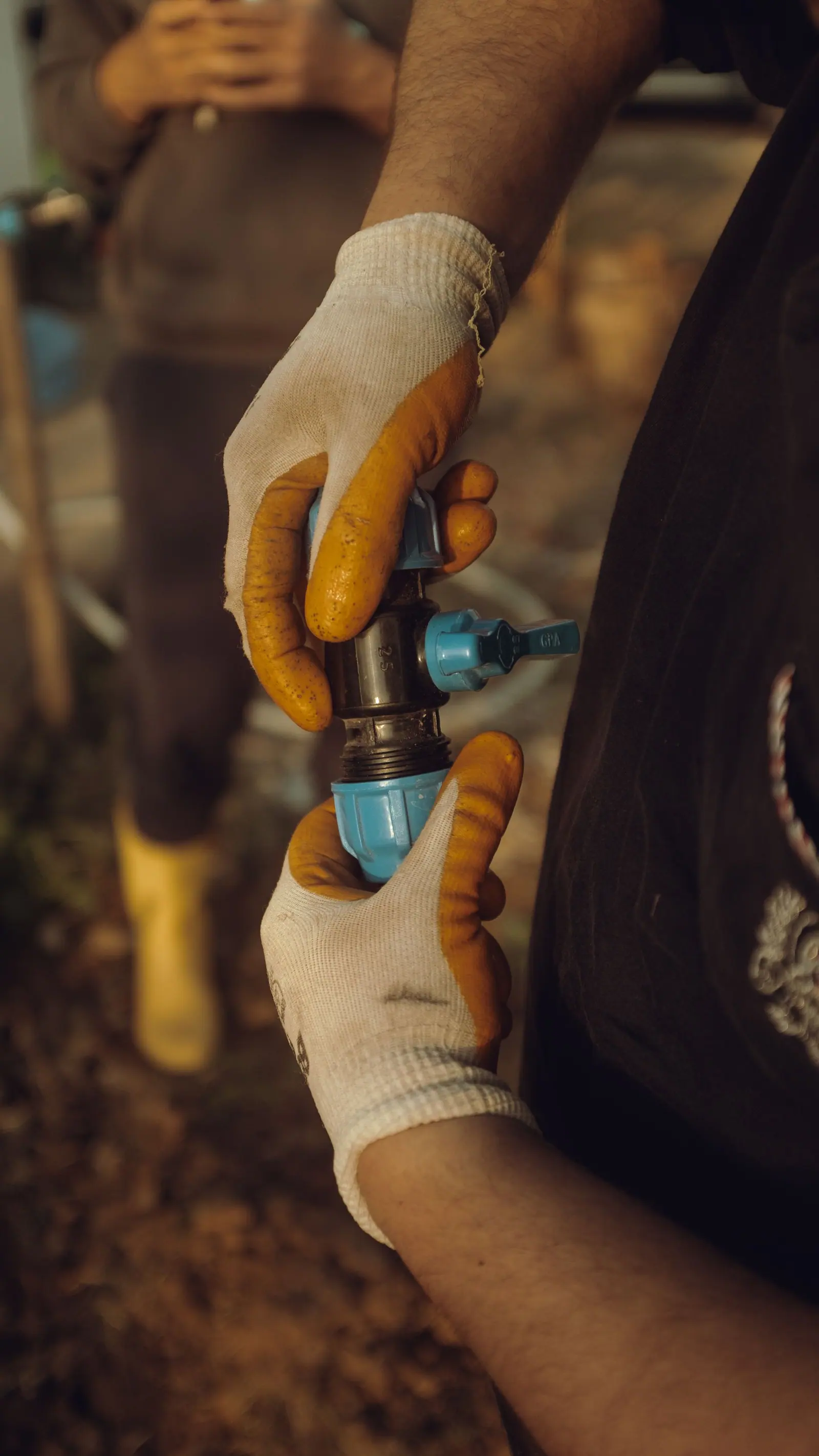 Mains gantées d'un professionnel assemblant une canalisation lors du remplacement d'une installation